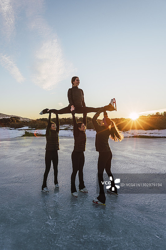 在日落时分冰冻的湖面上练习花样滑冰的女子图片素材