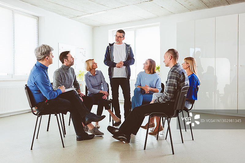 患者和指导员听一位年长的男人讲话图片素材