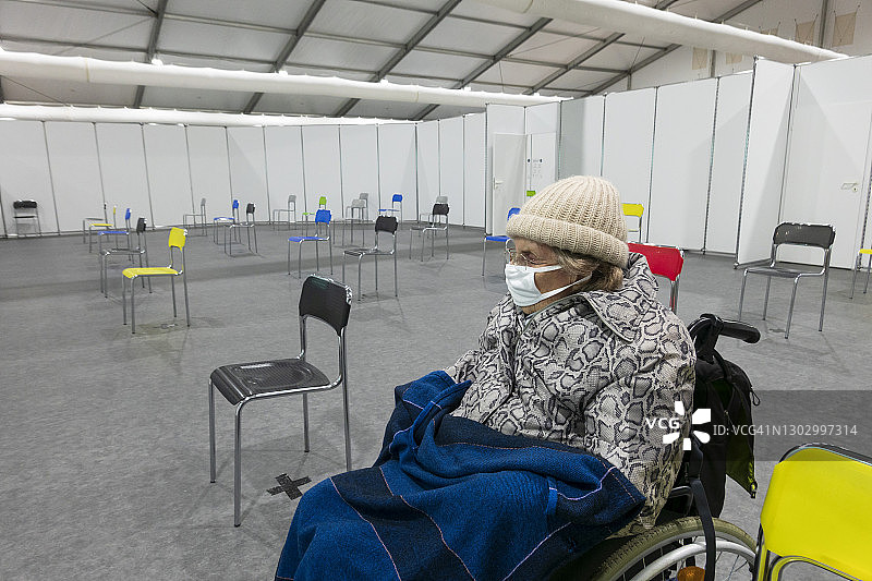 老年女性戴口罩坐轮椅在疫苗中心图片素材
