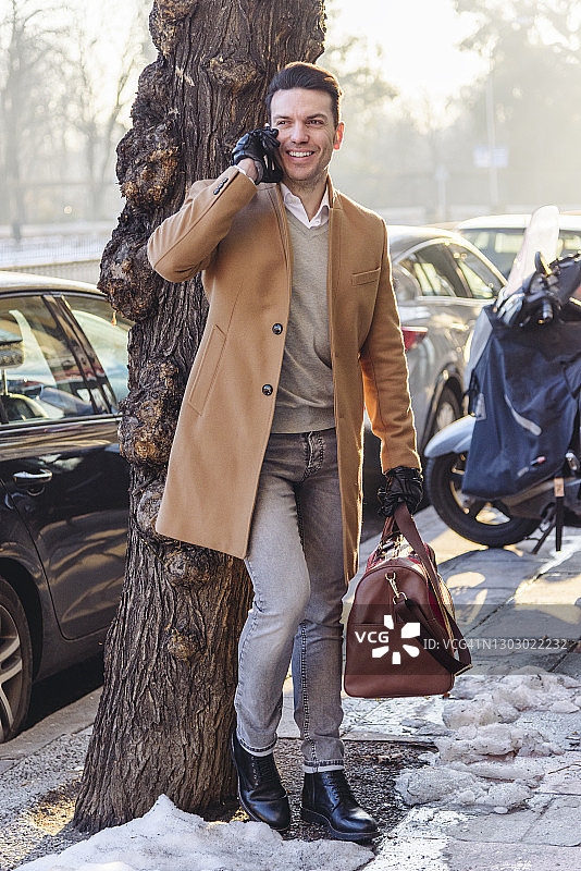 男子在城市里用智能手机交谈图片素材