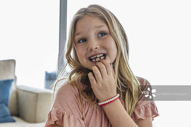 可爱的女孩展示掉落的牙齿图片素材