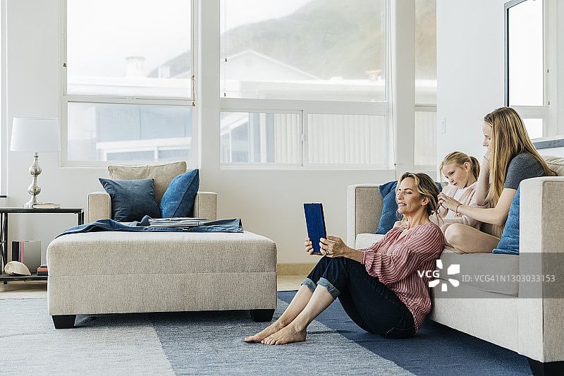 母亲和女儿们在家中客厅放松图片素材