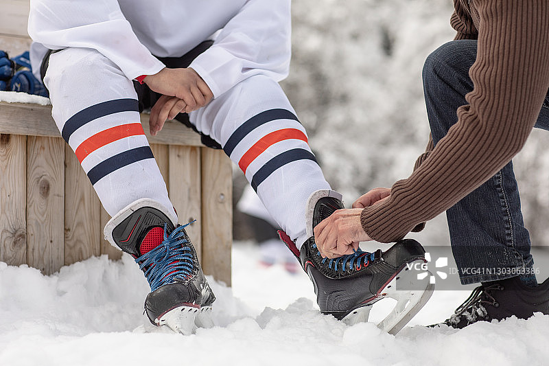 在户外溜冰场系冰鞋带的成年人图片素材