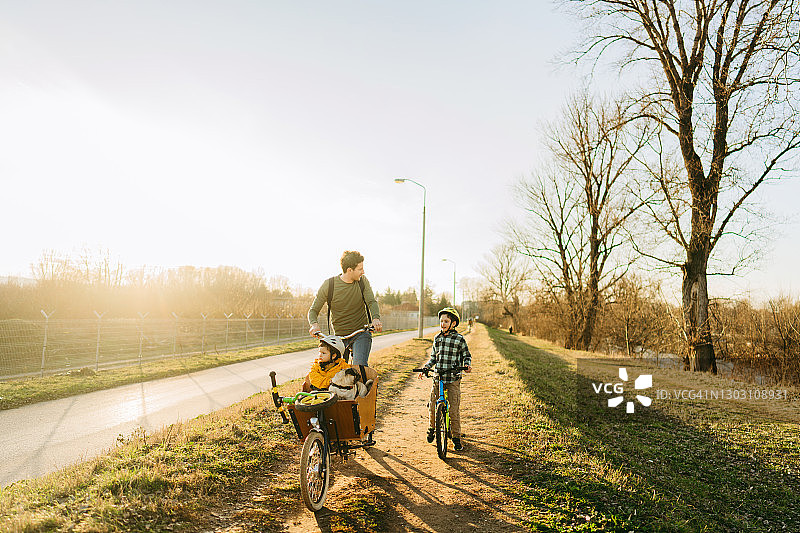 两个男孩和他们的父亲一起享受骑自行车图片素材