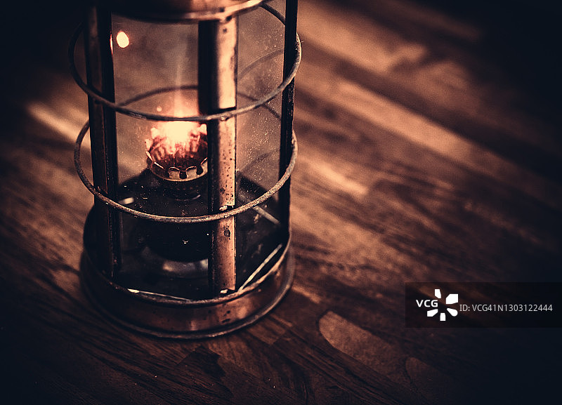 木桌上的旧锈油灯图片素材