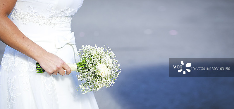 美丽白婚纱与新娘手捧白玫瑰捧花图片素材