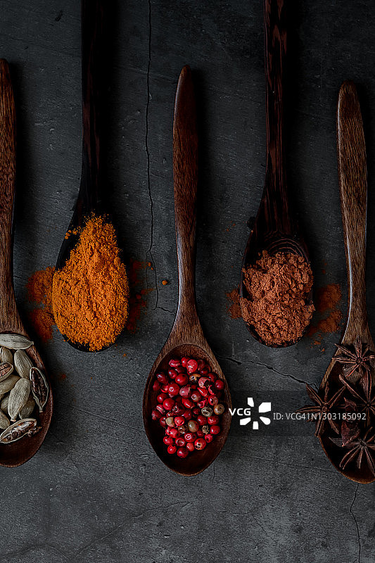 深色背景下的异域风情印度香料和木勺图片素材