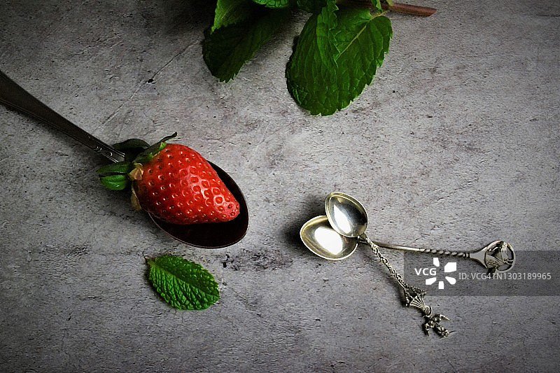 草莓和银色茶匙图片素材