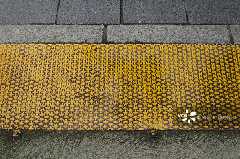 带交叉阴影防滑纹和混凝土人行道的黄色锈迹钢板图片素材