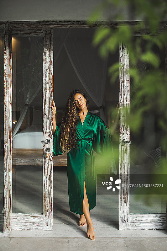 丝绸睡裙美女的觉醒：酒店度假的早晨图片素材