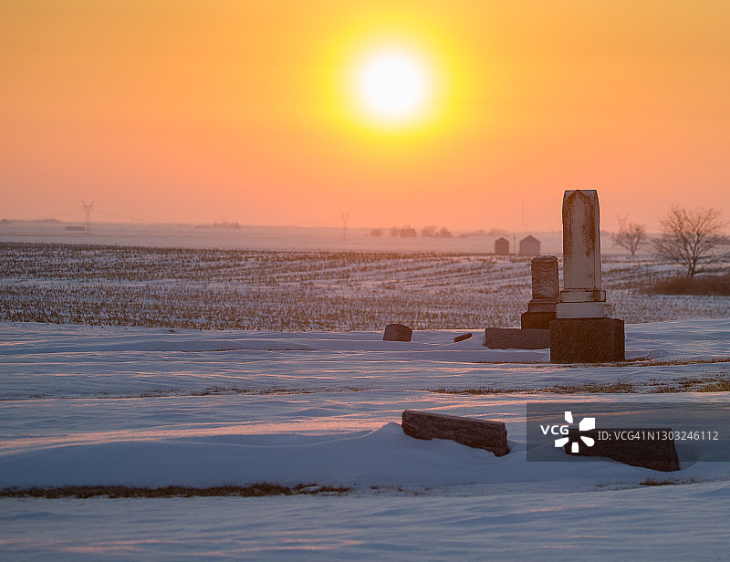日落时分白雪覆盖的古老墓地图片素材