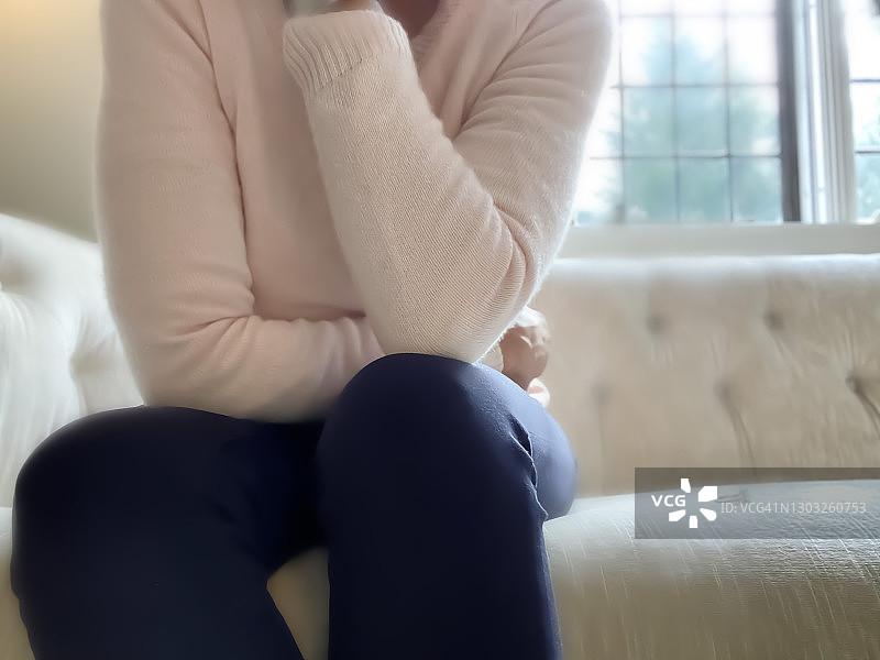 非裔美国女性坐在沙发上，订婚戒指放在旁边的座位上图片素材