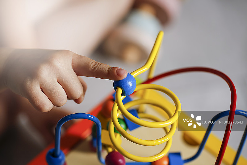 可爱的小宝宝玩耍着彩色木制互动玩具图片素材