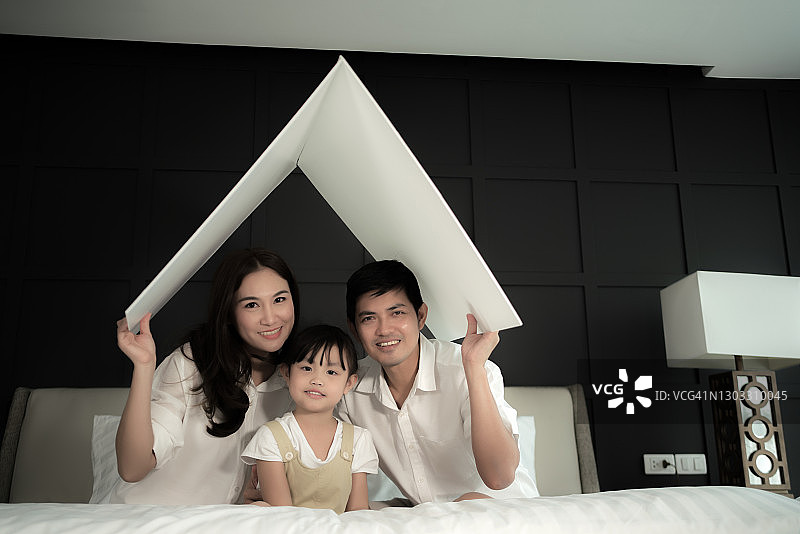 年轻家庭在卧室的床上图片素材