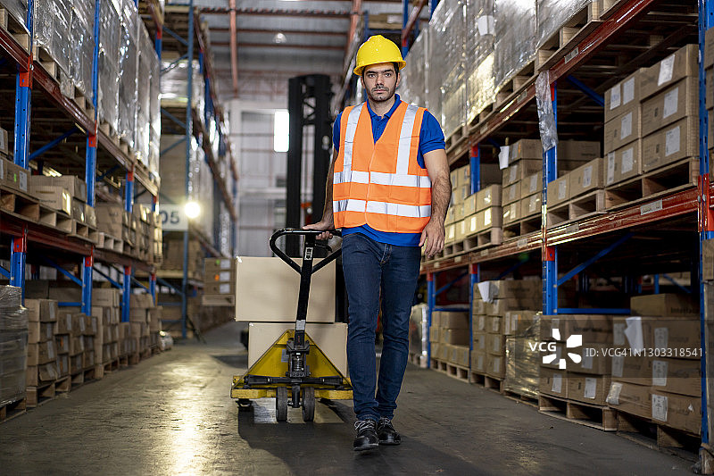 工人在仓库里用手推车搬运箱子图片素材