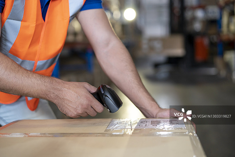 仓库工人手持条形码扫描器扫描包裹盒图片素材