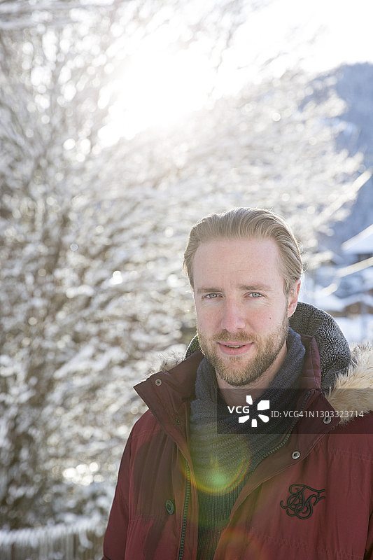 年轻男子在雪树前微笑看向镜头图片素材