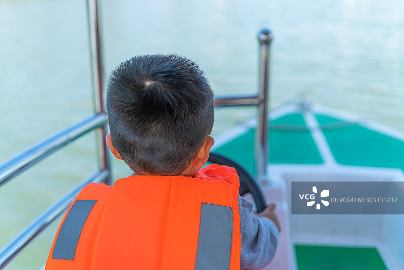 小孩在开玩具船图片素材