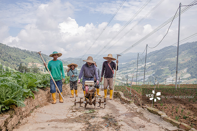 亚洲男农民携带工具在工作后返回图片素材