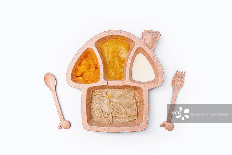 白色背景食物分隔盘中的婴儿食品泥图片素材