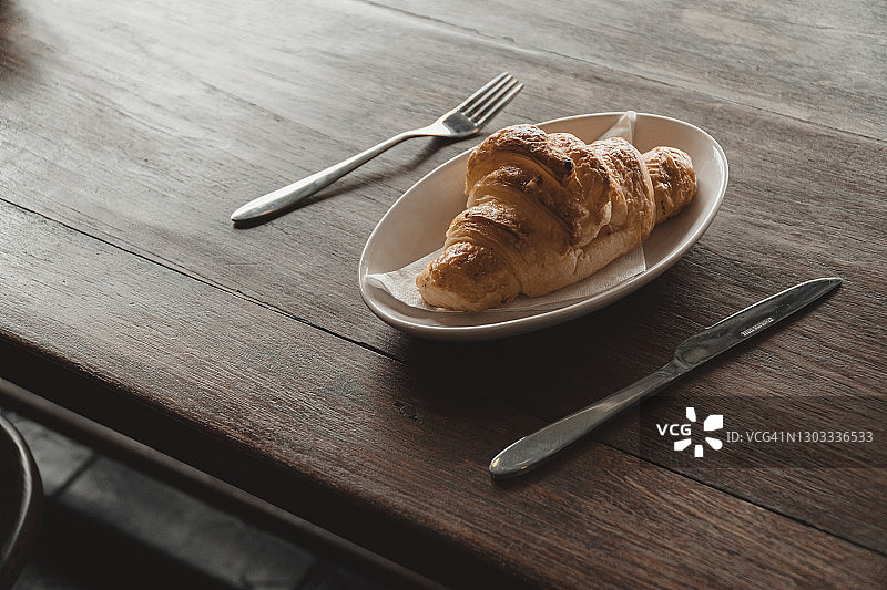 办公桌上香气扑鼻的美味牛角面包图片素材