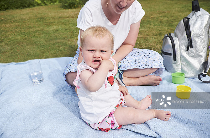 母亲和宝宝坐在蓝色毯子上图片素材