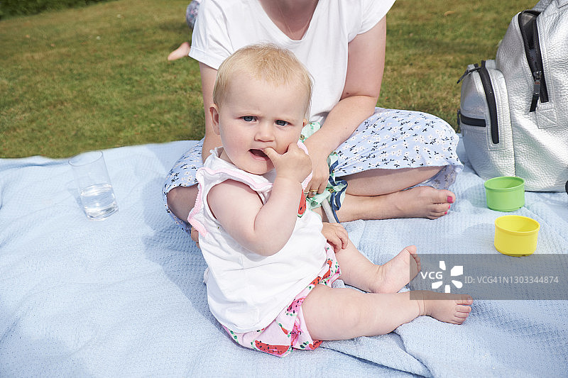 母亲和宝宝坐在蓝色毯子上图片素材