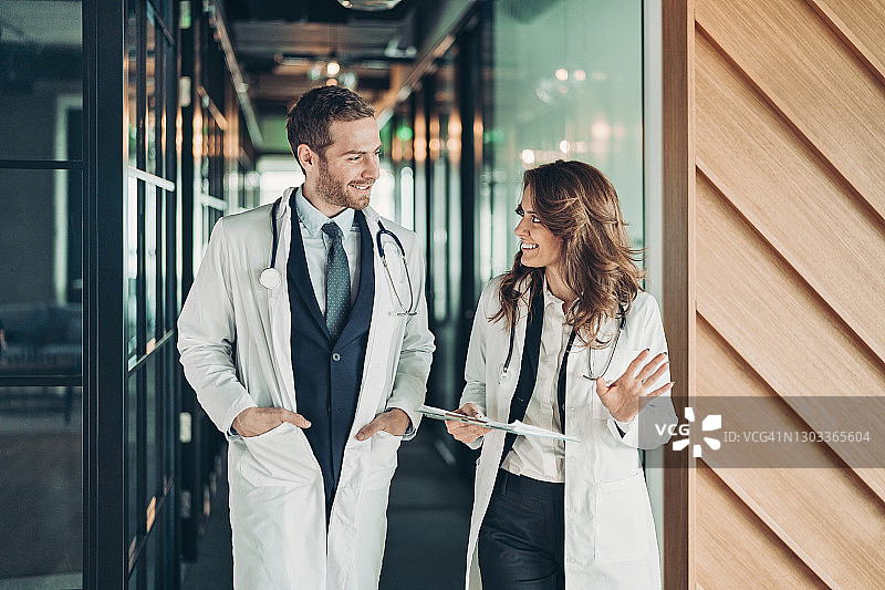 微笑的医生在走廊里交谈图片素材
