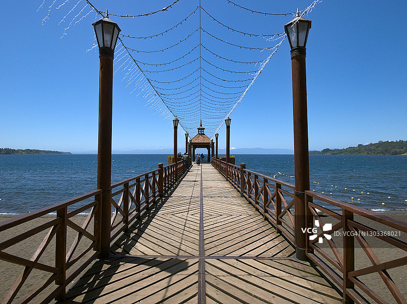 智利弗鲁蒂利亚，通往巴塔哥尼亚湖的火山沙滩的木制码头桥图片素材