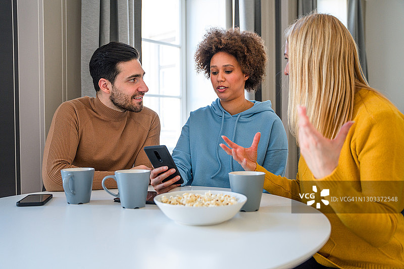 朋友们在家一起用手机在线搜索信息图片素材