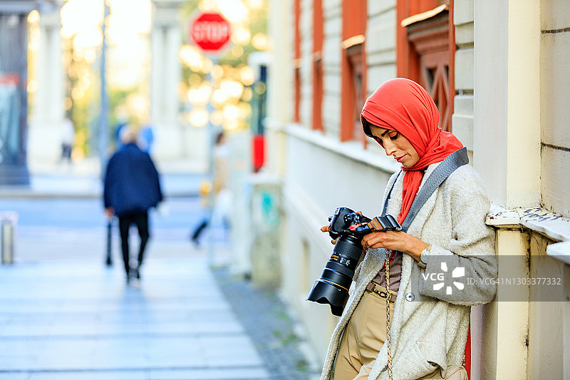 穆斯林女人用单反相机拍照图片素材