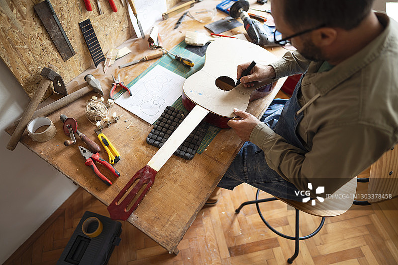 白人匠人在制作原声吉他图片素材