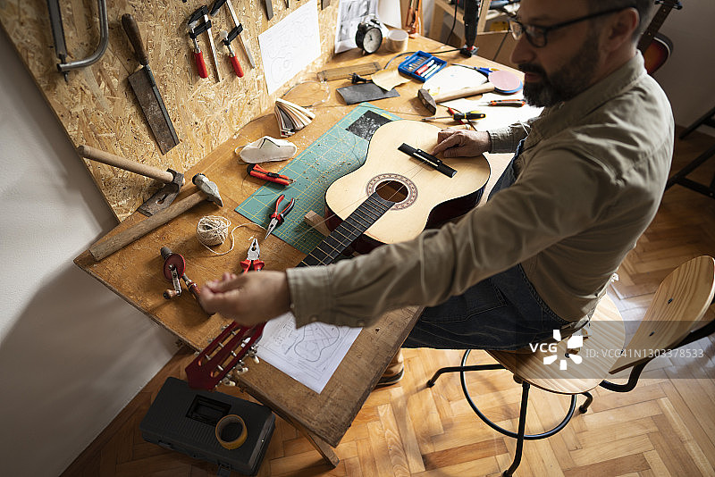 工匠在自家小型工作室制作吉他图片素材
