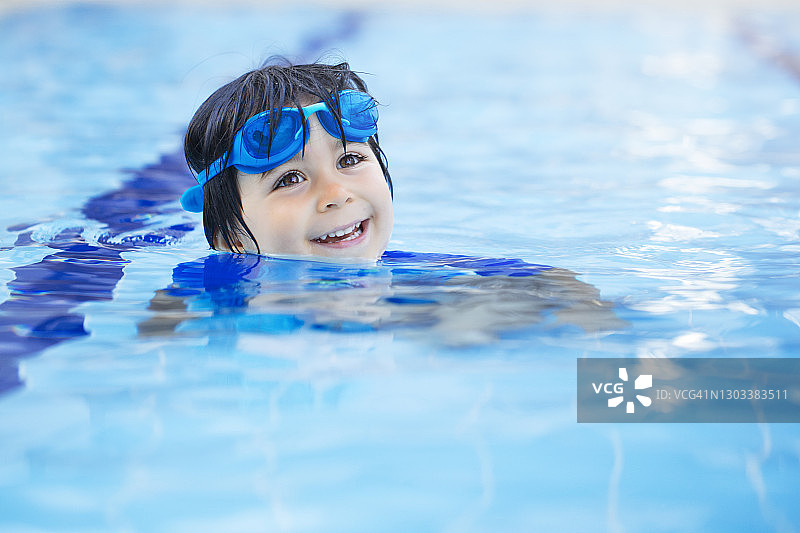 快乐的男孩在游泳池享受夏日时光图片素材