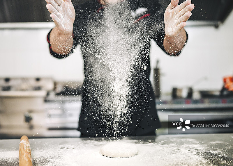 男厨师在厨房准备披萨图片素材