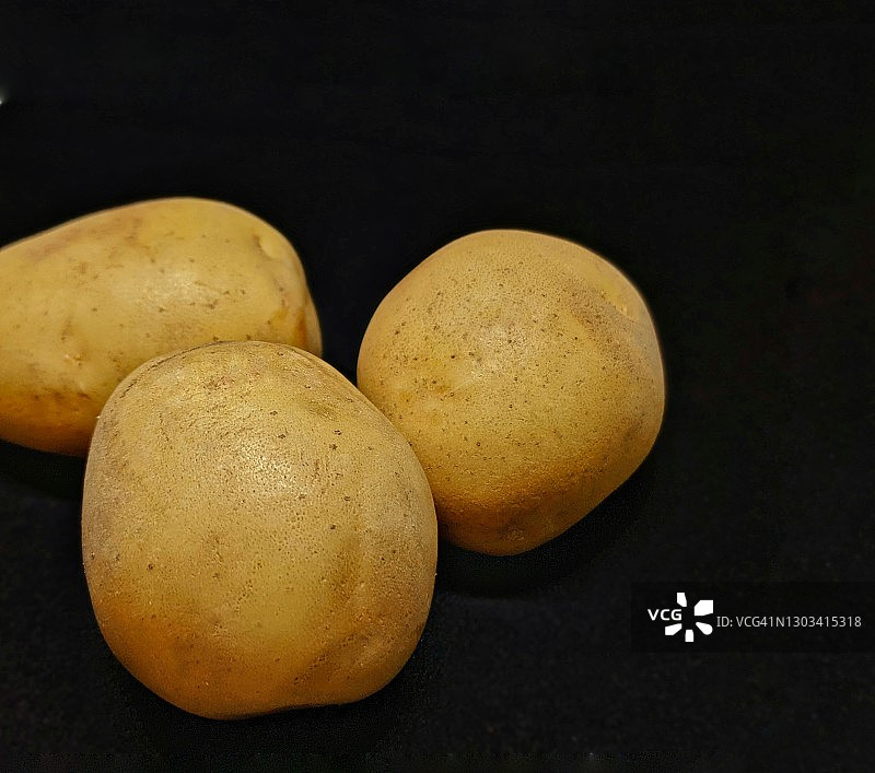黑色背景下的土豆图片素材