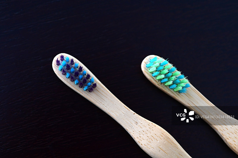 黑色背景上隔离的两把木制牙刷图片素材