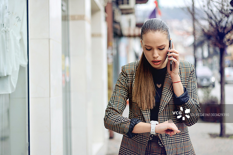 使用智能手机的年轻有为的女商人图片素材