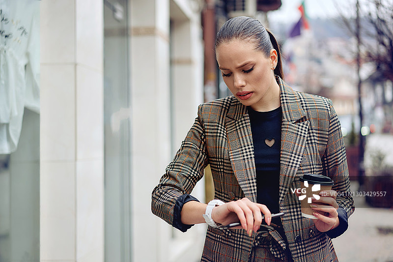 使用智能手机的年轻有为的女商人图片素材