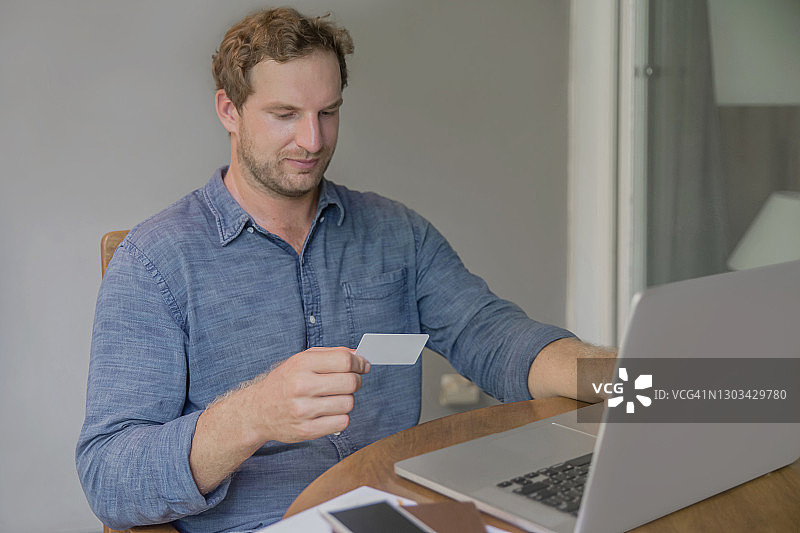 白人商人使用信用卡通过笔记本电脑在线支付账单图片素材