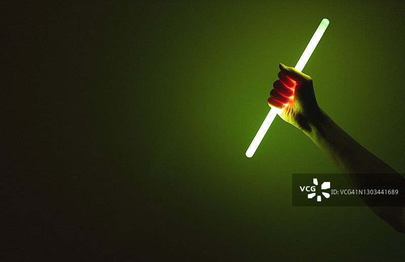 在黑暗中手持荧光棒图片素材