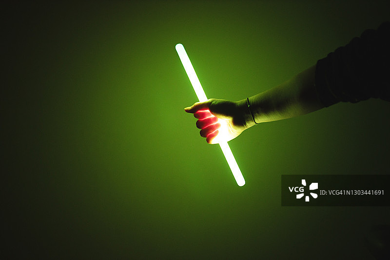在黑暗中手持荧光棒图片素材