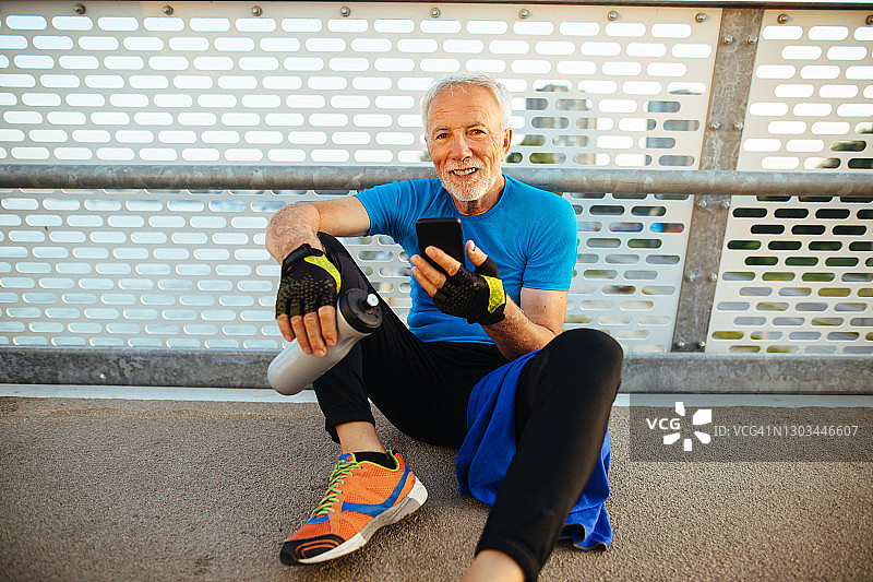 慢跑休息时使用手机的年长男人图片素材