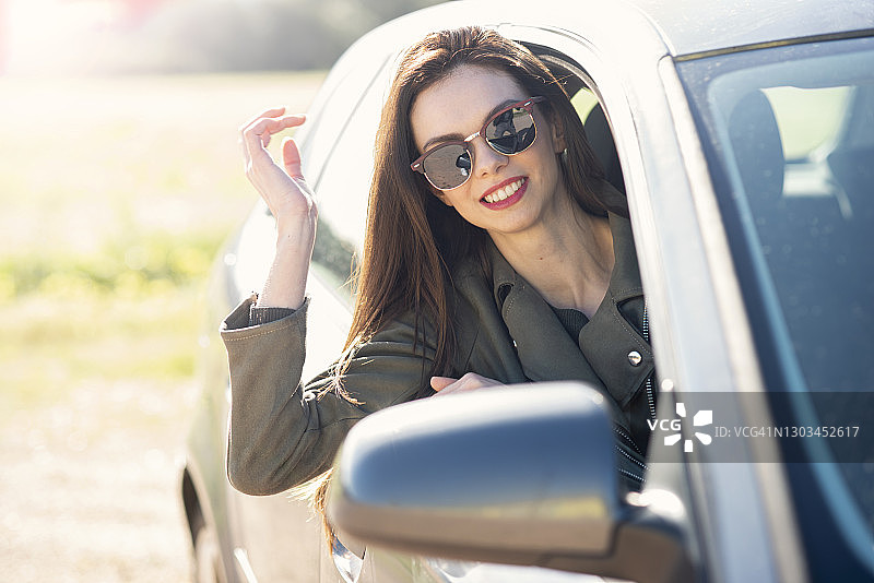 坐在车里照后视镜的虚荣女人图片素材