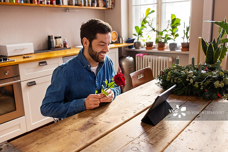 手持玫瑰与女友视频通话的男人图片素材