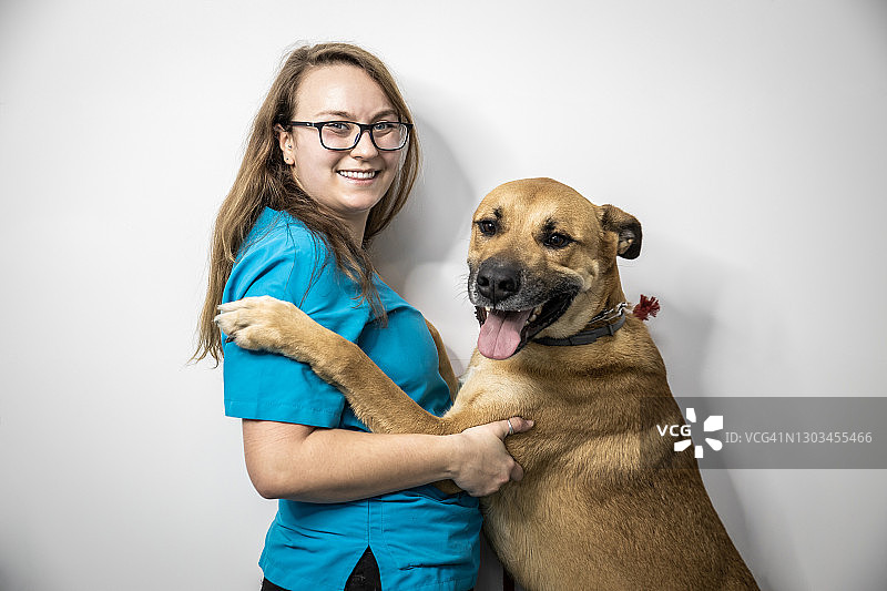 男兽医坐着拥抱一条大狗图片素材