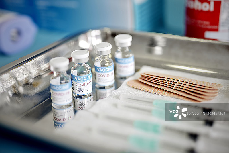 新冠疫苗药剂瓶和注射器在疫苗中心托盘上展示图片素材