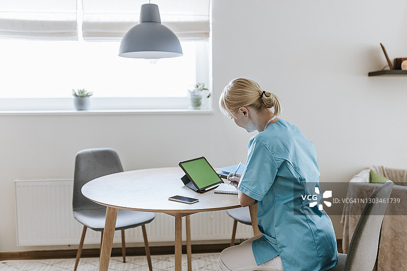 在家使用平板电脑的女护士图片素材