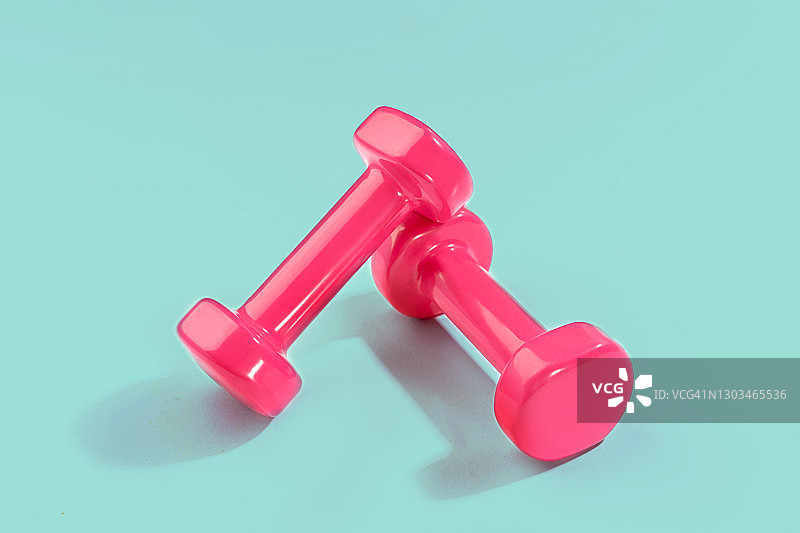 粉色哑铃与薄荷绿背景的运动生活方式概念图片素材