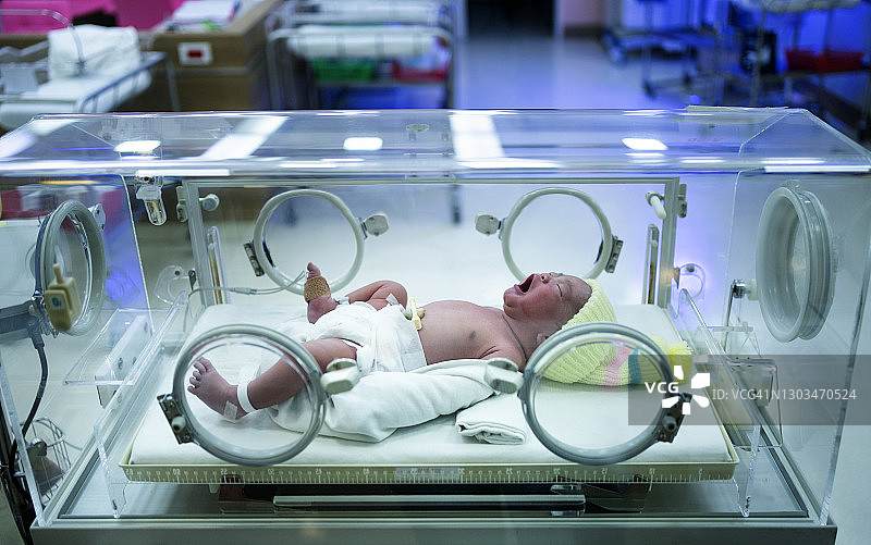 在保温箱中哭泣的亚洲新生儿特写，来到世界的第一天图片素材